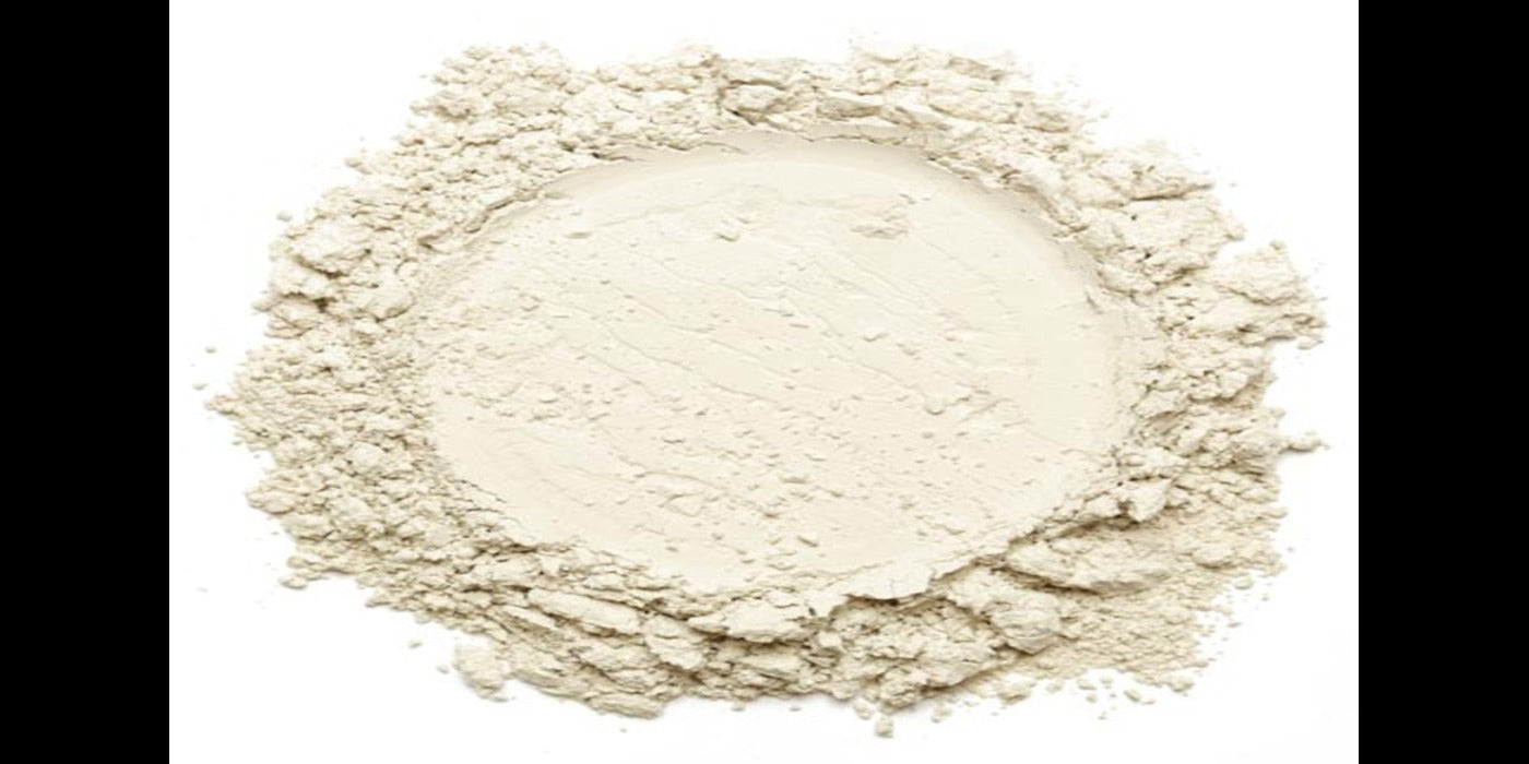 A pile of fine, white zero-carb whey protein powder on a smooth surface, symbolizing purity and clean nutrition.
